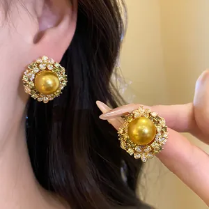 Detailed view of vintage gold plated zircon pearl earrings with floral halo design.