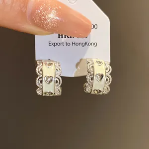 Vista detallada de pendientes de aro en forma de C con incrustación de corazón y encaje