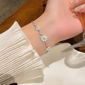 Vista detallada de una pulsera de margaritas de plata con circonitas en la muñeca de una mujer.