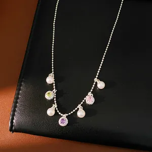 Close-up macro view of colorful zircon pendants and pearls on a silver-toned necklace