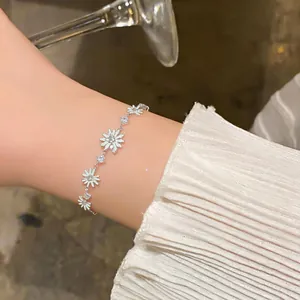 Elegante pulsera de margaritas de plata con cristales en la muñeca de una mujer