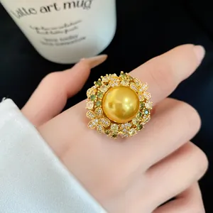 Close-up of vintage 18k gold plated ring with large golden pearl and zircon flowers