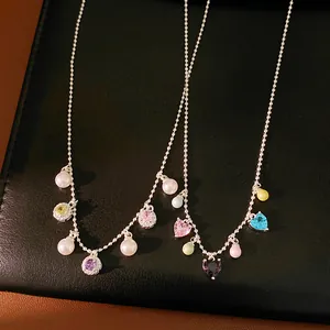 Detailed view of dainty necklaces featuring heart and round colorful zirconia with pearls