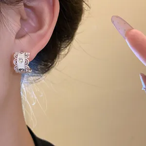 Vista detallada de elegantes pendientes de aro plateados con motivos de corazones y encaje