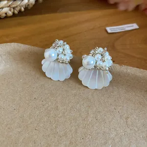 Detailed shot of French style shell flower earrings with clustered pearls and beads