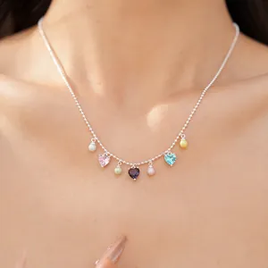 Close-up of a silver beaded necklace with colorful heart zircons and pastel pearls.
