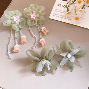 Elegantes pendientes de flores de gasa verde salvia con borlas de perlas y pinzas.