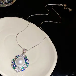 Detail view of a vintage 18k gold plated necklace with central pearl and zircons