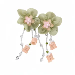 Elegantes pendientes de flores de gasa verde salvia con borlas de perlas y cuentas.