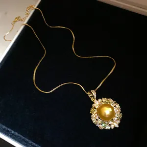 Detailed view of vintage gold plated necklace with pearl and zircon pendant in box