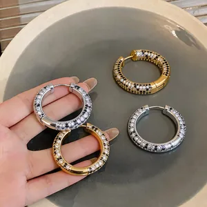 Close-up of luxury 18K gold plated hoop earrings with black and white zircons