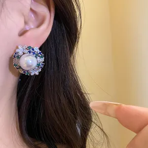 Detailed view of luxury vintage earring featuring a pearl and colorful zircon cluster.
