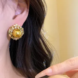Macro view of vintage 18k gold plated earring featuring a golden pearl and zircons