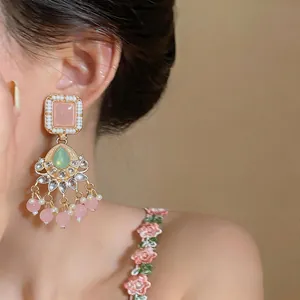 Detailed close-up of elegant vintage pink resin tassel earrings on a female model