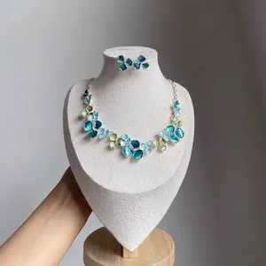 Detailed view of elegant blue and green floral enamel necklace and matching stud earrings set