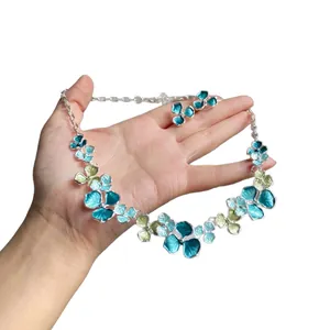 Elegant teal floral enamel jewelry set featuring a necklace and matching stud earrings