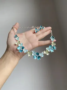 Detailed view of elegant blue and green floral enamel necklace and earrings set