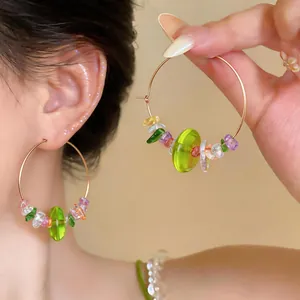 Detailed shot of large hoop earrings with vibrant colorful resin beads on a model