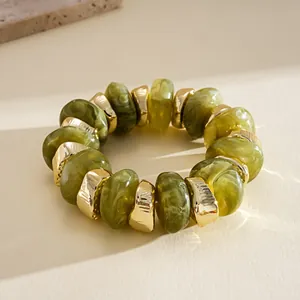 Close-up of retro green marbled acrylic and gold irregular beaded stretch bracelet