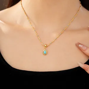 Détail du collier doré 18 carats avec pendentif en goutte d'eau porté