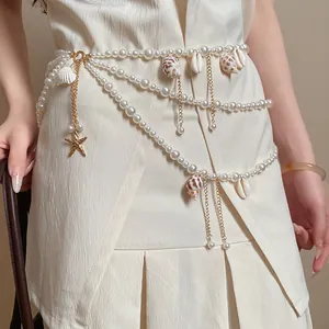 Detail view of a multilayered pearl waist chain with seashell and starfish charms