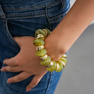 Close-up detail of a chunky olive green acrylic and gold bead stretch bracelet for women