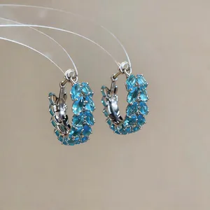 Detail shot of silver hoop earrings with marquise-cut blue zircons in wheat ear design