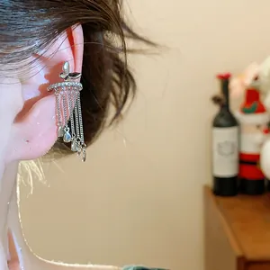 Close-up of silver butterfly ear cuff with zircon band and long teardrop tassel chains