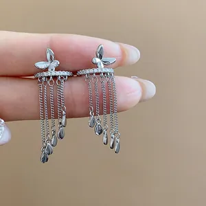 Close-up of silver butterfly ear clips with zircon and tassel water-drop pendants