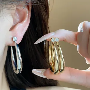 Close-up of 18k gold plated silver needle hoop earrings with zircon studs for women.