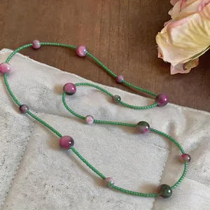 Detailed view of fresh forest style cat's eye beads and green seed beads necklace