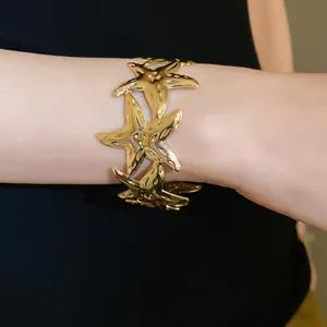 Detail shot of a gold starfish open cuff bracelet for women, elegant fashion jewelry