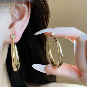 Detail of 18k real gold plated hoop earrings with zircon studs for elegant look