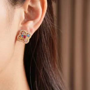 14k gold plated clover flower stud earrings with colorful zircons worn on model ear