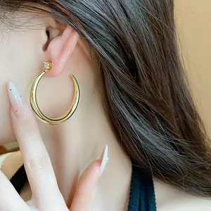 Detailed close-up showing a luxury 18k gold plated zircon hoop earring on a model's ear