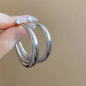 Detailed close-up showing silver-plated hoop earrings featuring sparkling zircon accents
