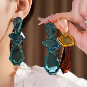 Large irregular geometric resin drop earrings with silver needles in teal and amber tones