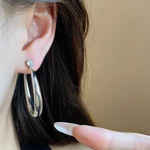 Close-up detail of silver-plated hoop earring with a sparkling zircon stud on ear.