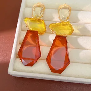Statement irregular resin drop earrings with geometric amber and yellow segments.