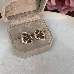 Detail of French retro style geometric stud earrings with elegant pave-set diamonds