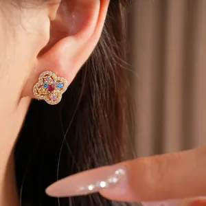 Close-up of colorful flower stud earrings with 14k gold plating shown on the ear