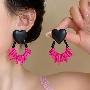 Elegant statement heart earrings featuring pink acrylic dangles and black matte heart studs