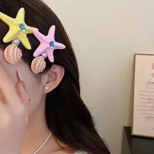 Beach style hair clips featuring colorful starfish and shell designs with pearl accents.