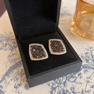 Close-up of vintage silver needle stud earrings with black and white pave diamond accents