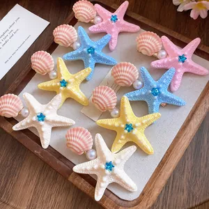 Close-up of colorful starfish and shell hair clips with pearl and rhinestone accents.