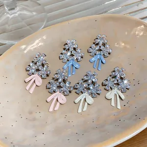 Macro de pendientes de flores de plata con brillantes diamantes de imitación y lazos de colores.