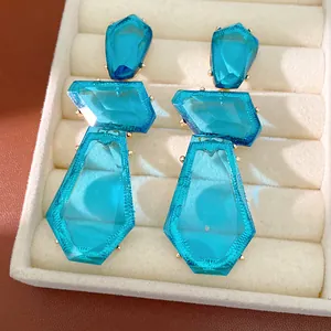 Close-up of bright blue irregular geometric resin earrings in a jewelry box