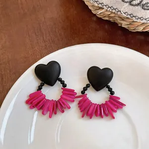 Elegant black heart stud earrings featuring vibrant pink acrylic fringe tassels.