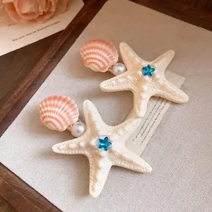 Detailed view of beach-themed starfish and shell hair clips for summer vacations.