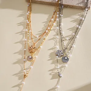 Detailed macro shot of multi-layer pearl and shell flower necklaces in gold and silver finish